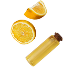 Clear glass bottle with cork lid next to sliced lemons on a white background